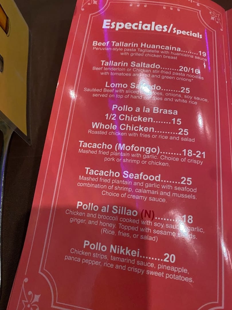 A close-up view of a red menu displaying various Peruvian special dishes and their prices.