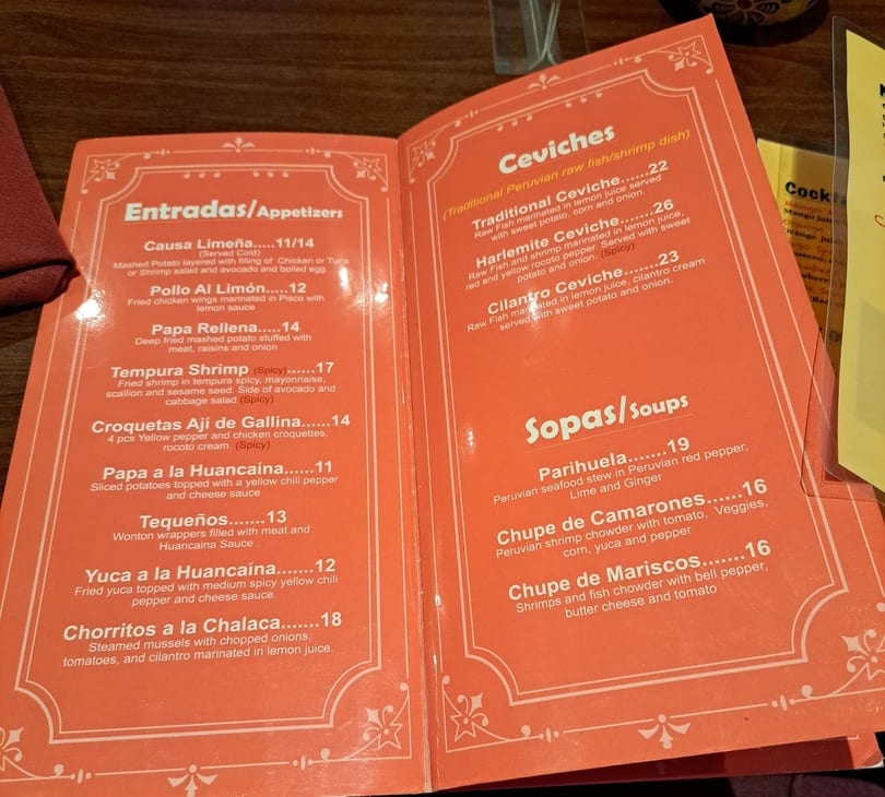An open orange menu displays appetizers, ceviches, and soups with descriptions and prices.