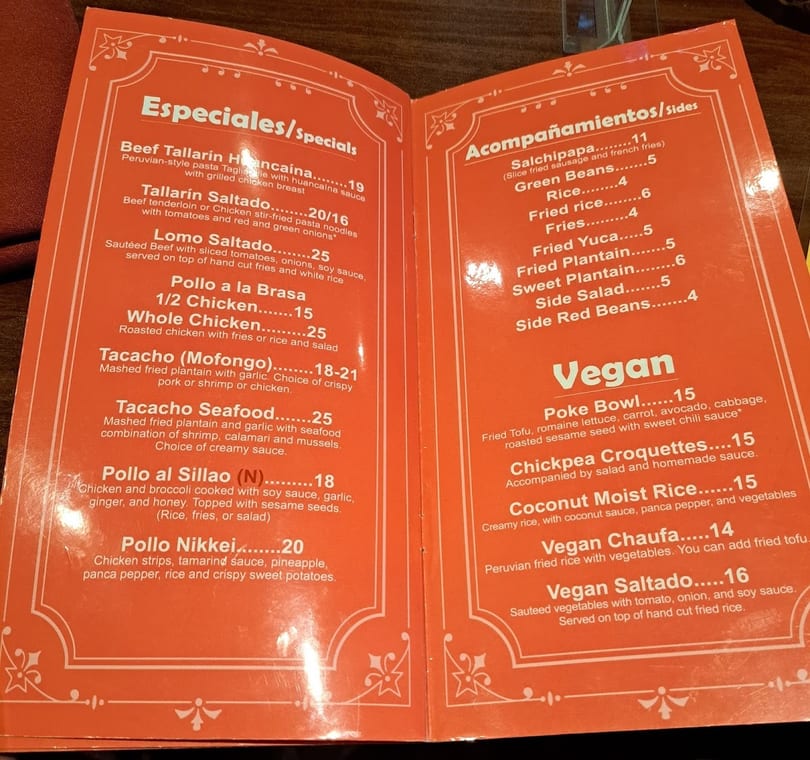 A close-up view of a Peruvian restaurant's menu, featuring specials, sides, and vegan options.