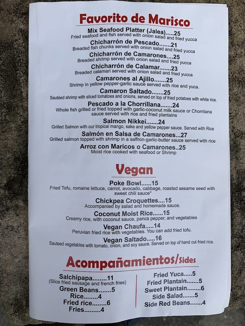 A white paper menu displays a variety of seafood, vegan, and side dishes with prices.